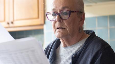 Protect yourself from scams image A woman examines some paperwork.