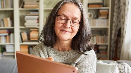 Your rights with financial services image A woman is smiling while scrolling on her iPad